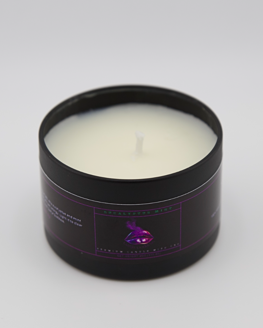Eucalyptus mint candle in a black container with a purple label on a white background